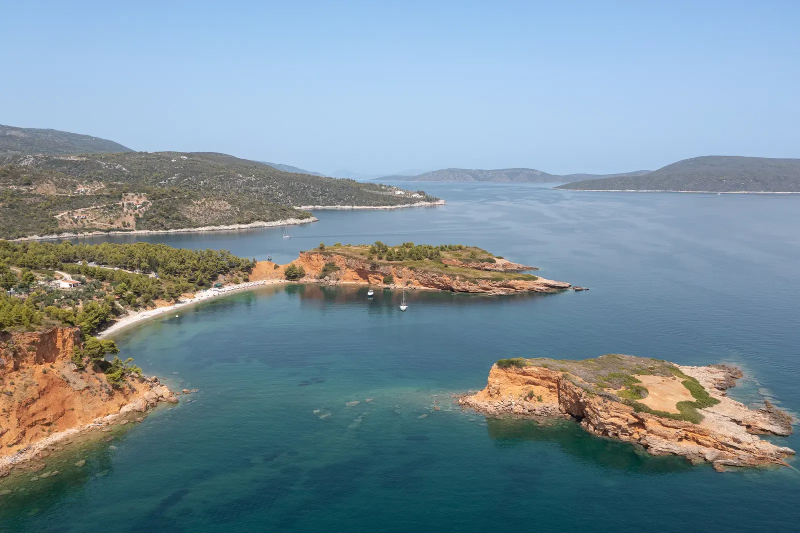 Red cliffs and islet of Kokkinokastro above turquoise shallows, Alonissos