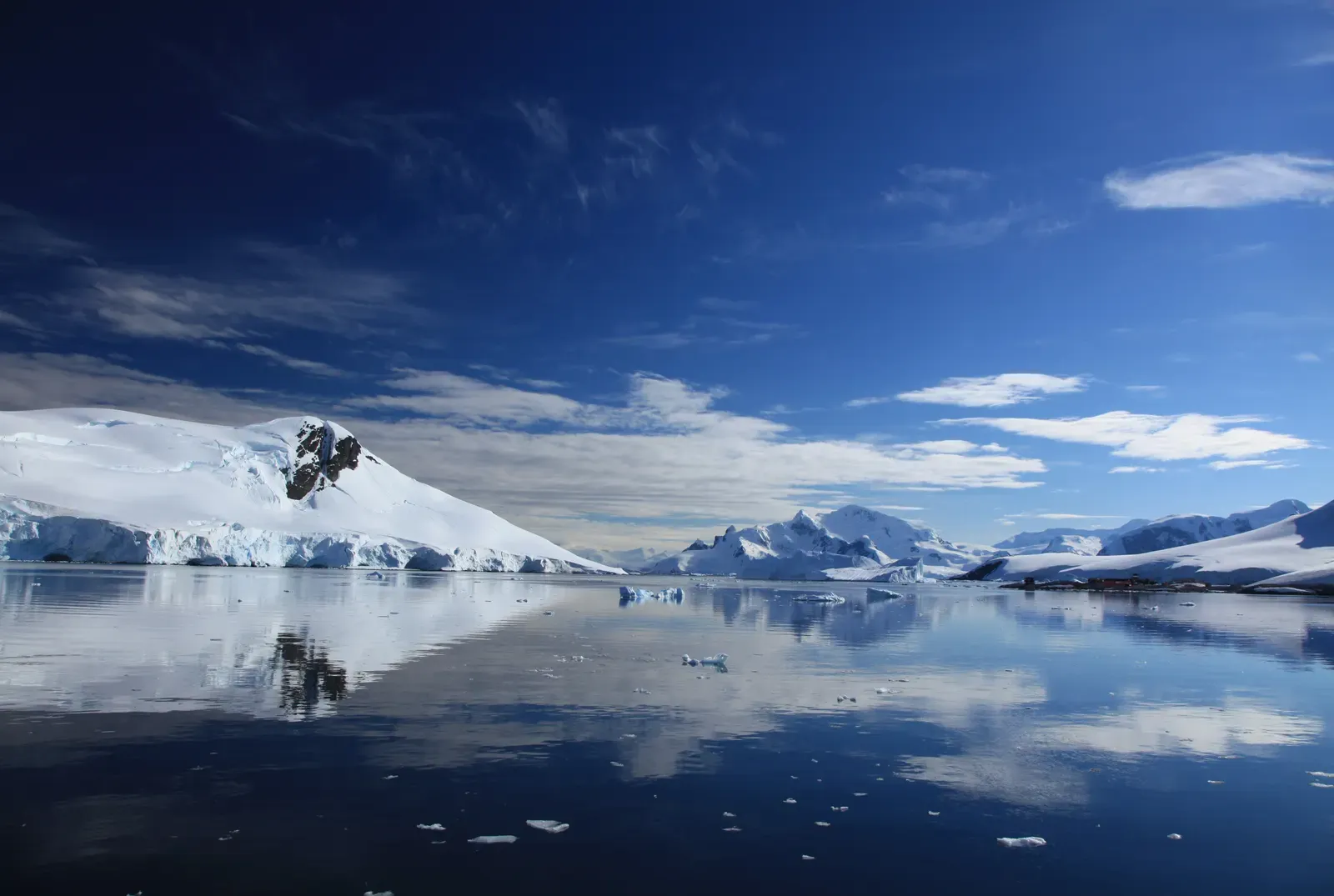 Snow-covered peaks and glaciers reflect in the still water of Paradise Harbour, Antarctica