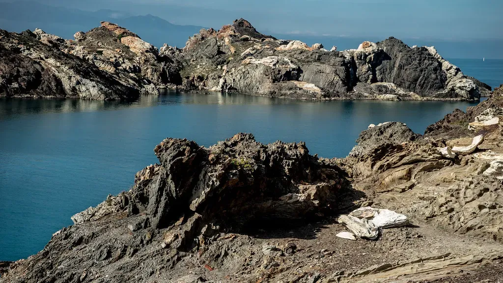 Folded schist headlands of Cap de Creus enclosing a deep blue inlet