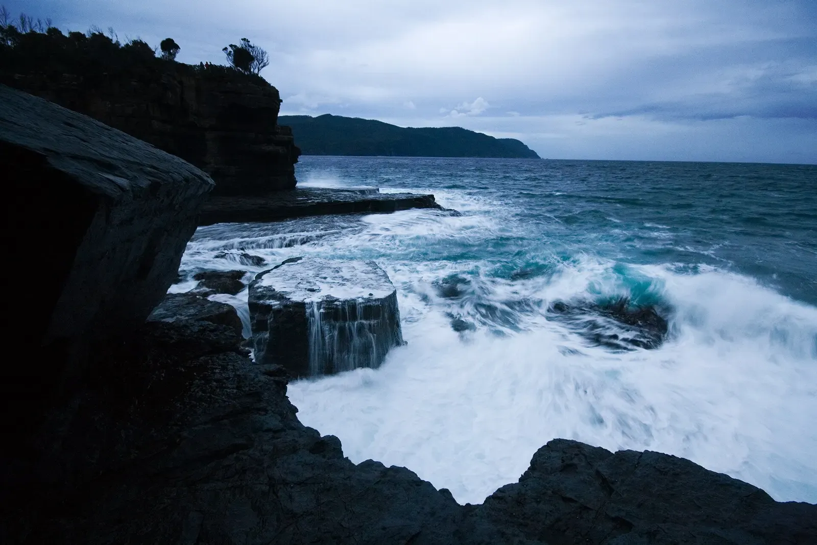 Waves crash into a rocky inlet at Fossil Bay on the Tasman Peninsula near Eaglehawk Neck.