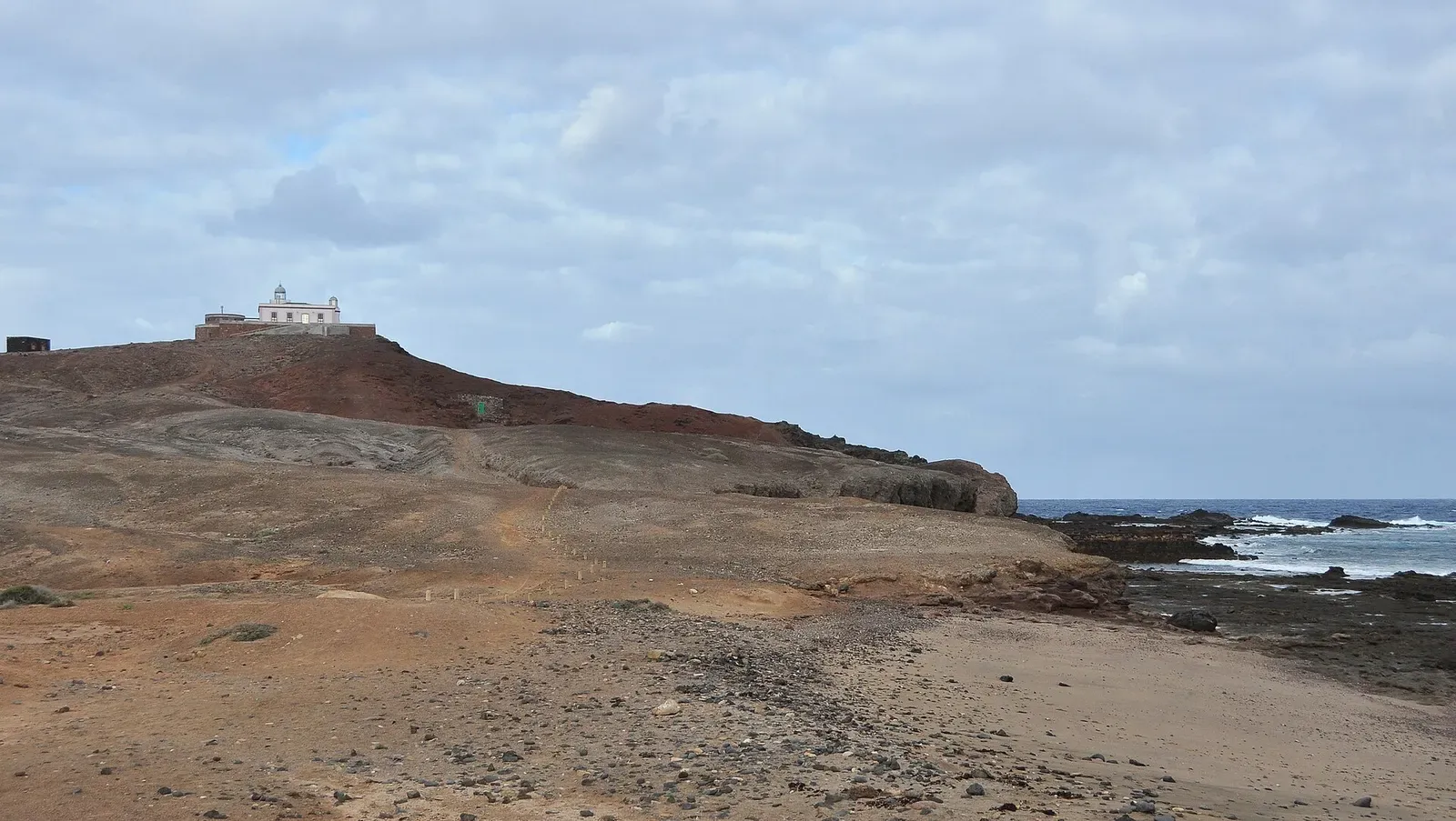 The rocky, arid headland of Punta de Arinaga on Gran Canaria's east coast, with its lighthouse on top.