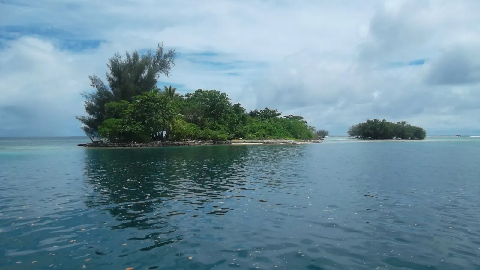 Small forested islet on Pohnpei's southern barrier reef, ringed by shallow turquoise water