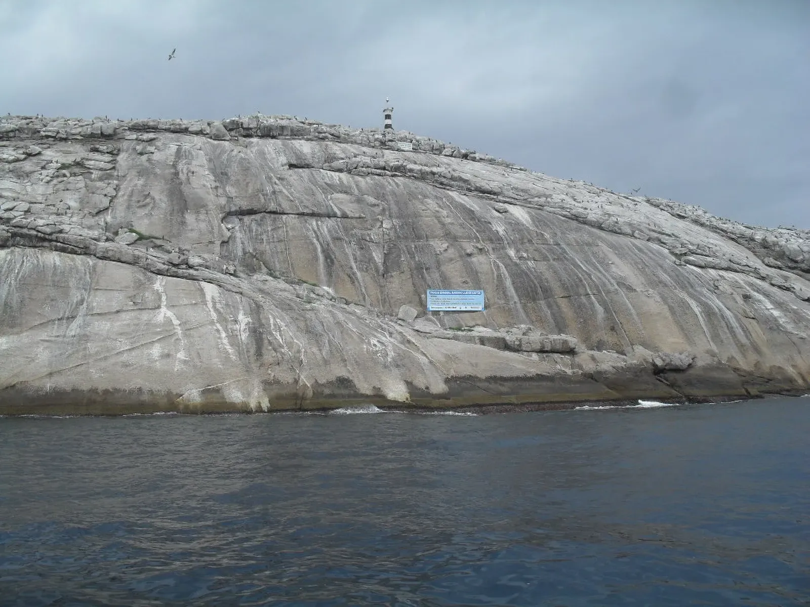 Granite islet of Laje de Santos rising from the sea, seen from a dive boat