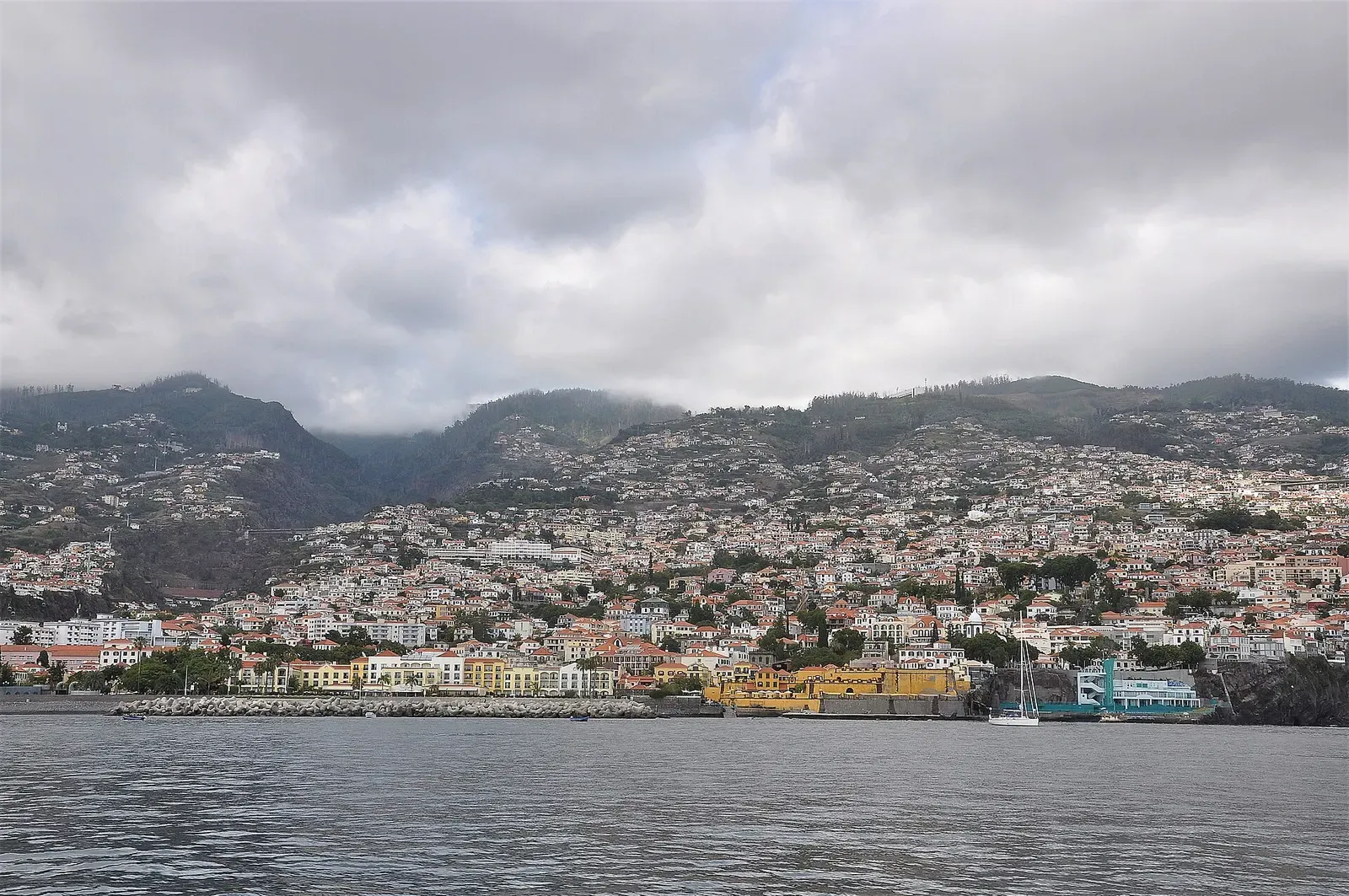 Funchal's amphitheatre of white buildings climbs the green hillside above its seafront and breakwater
