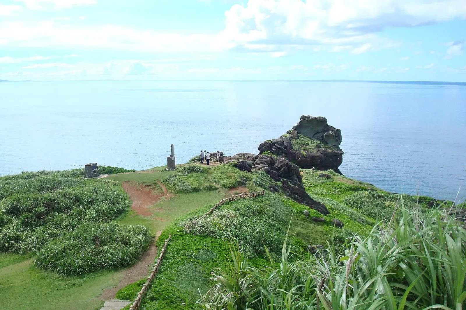 Visitors walk a grassy trail along the sea cliffs of Cape Ugon on Ishigaki's west coast.