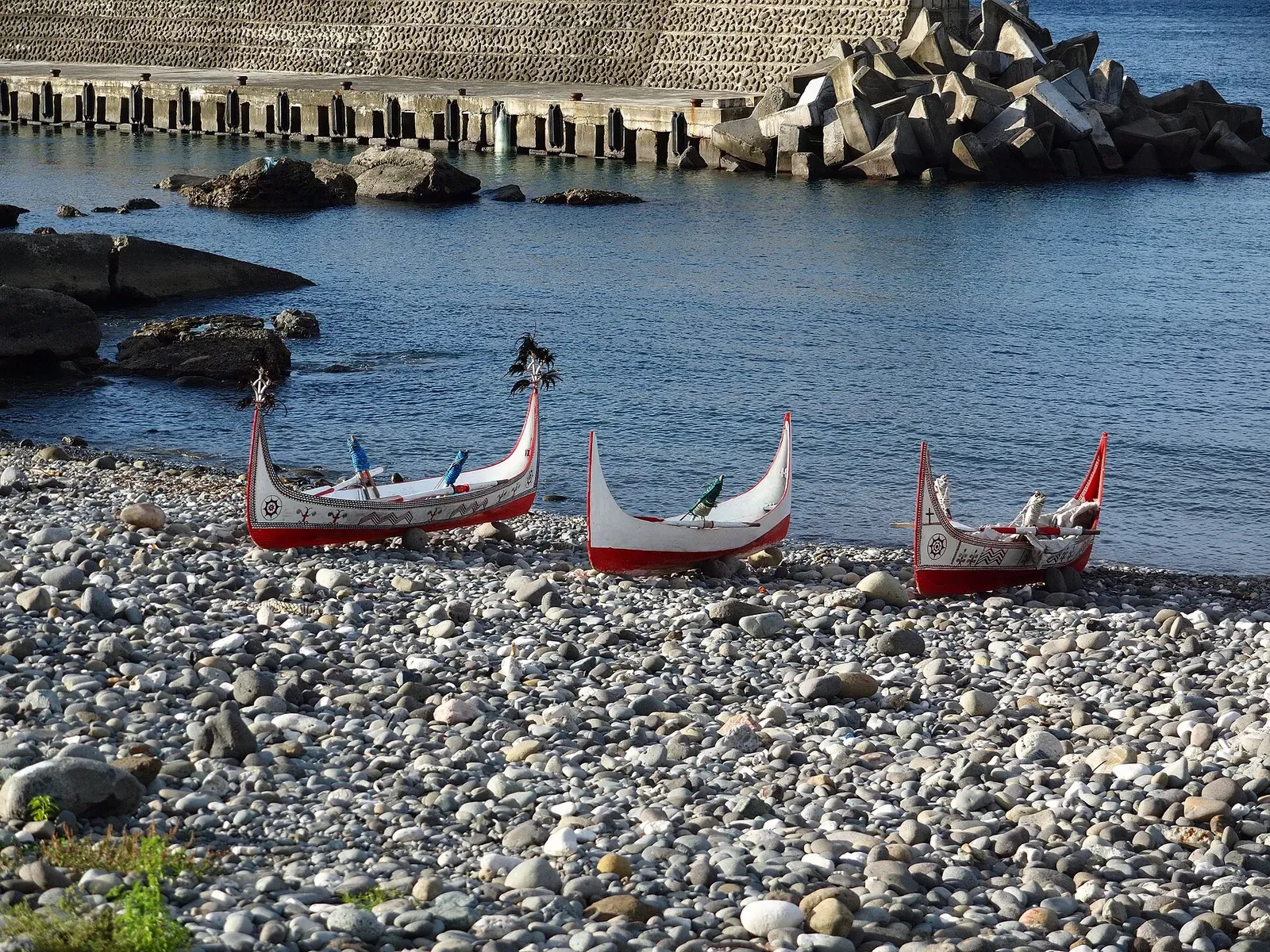 Traditional Tao outrigger canoes pulled up on the pebble beach at Langdao Harbor, Lanyu