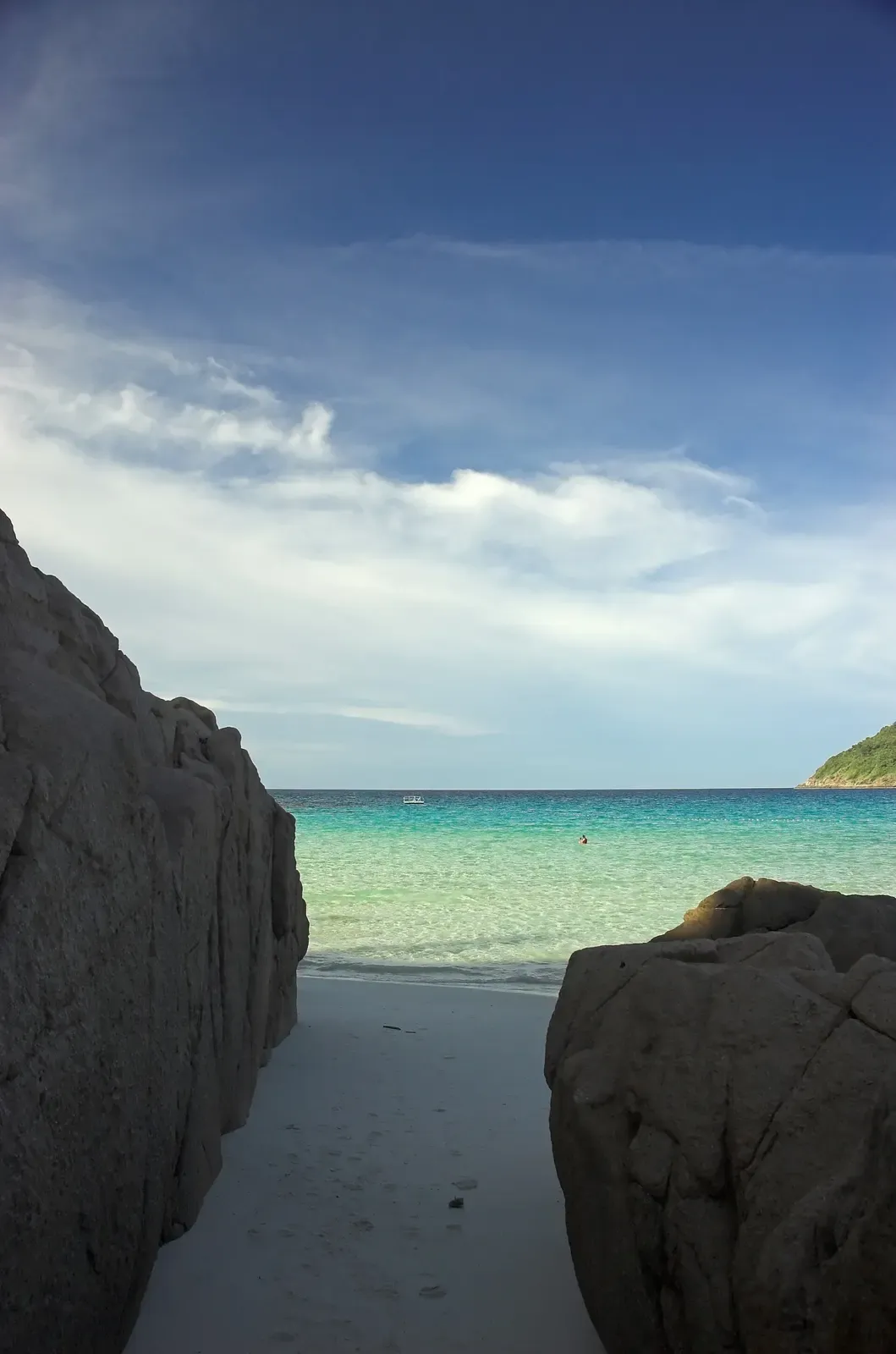 Granite boulders frame a turquoise cove on Perhentian Island, Malaysia.