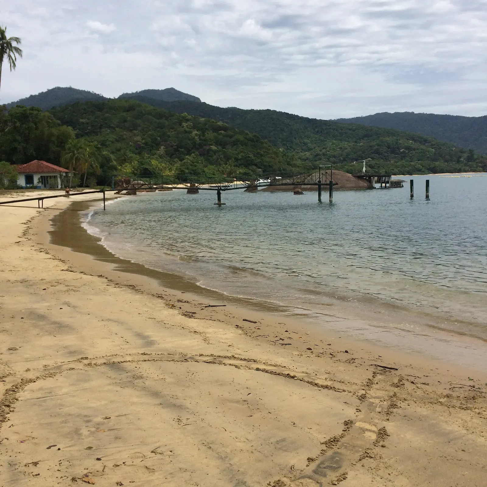Sandy cove with a small pier and forested hills on Ilha Grande, Brazil