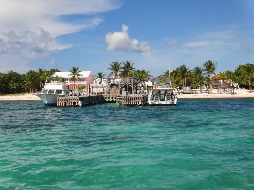 Dive boats moored at a resort dock over clear turquoise water in Little Cayman