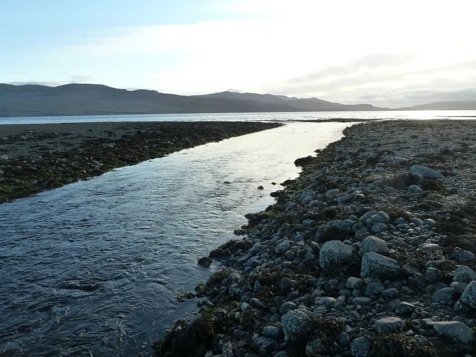 Savary River flowing over a rocky shoreline into the Sound of Mull