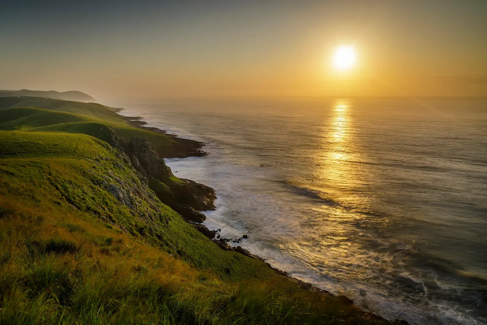 Sunrise over rugged green cliffs and open ocean along the Wild Coast near Port St Johns.