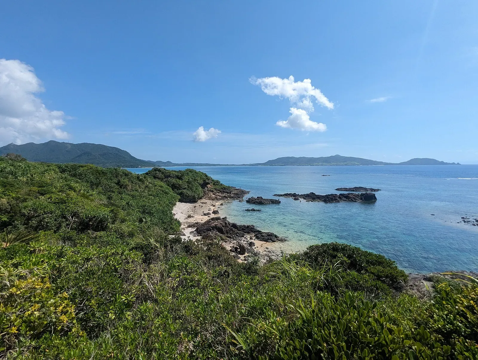 An elevated view over a turquoise cove near Kabiraishi-zaki, close to Ishigaki's manta ray dive sites.