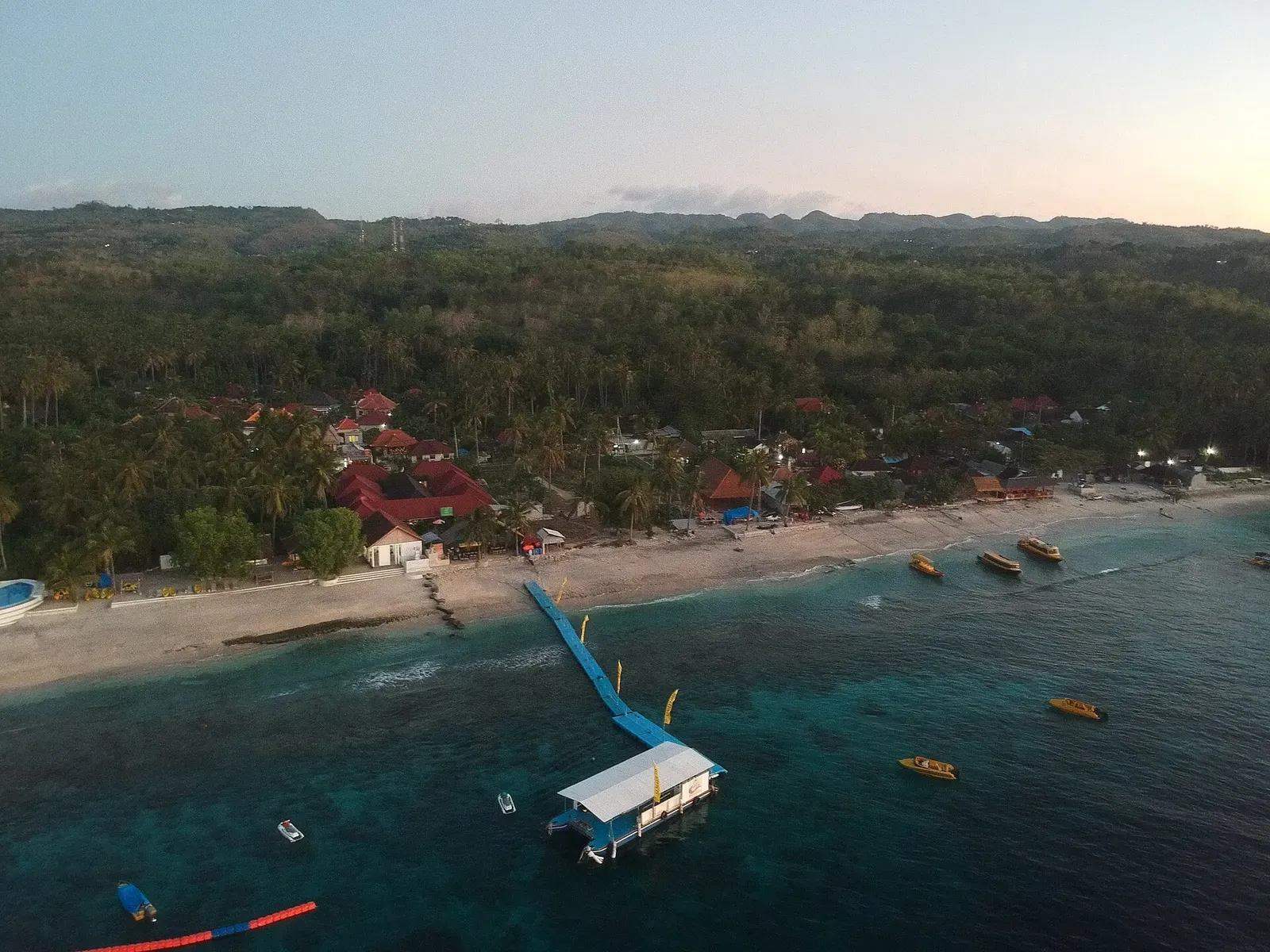 Dive boats and a floating dock at Buyuk Harbour on Nusa Penida at dusk