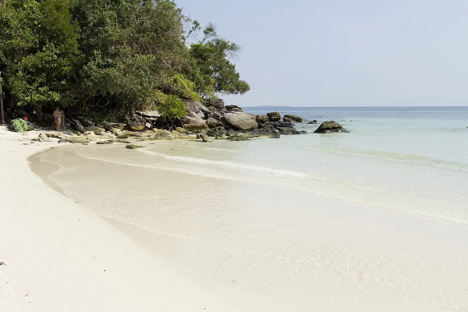 Jungle-covered rocky point meets a narrow sandy beach on the coast near Koh Rong