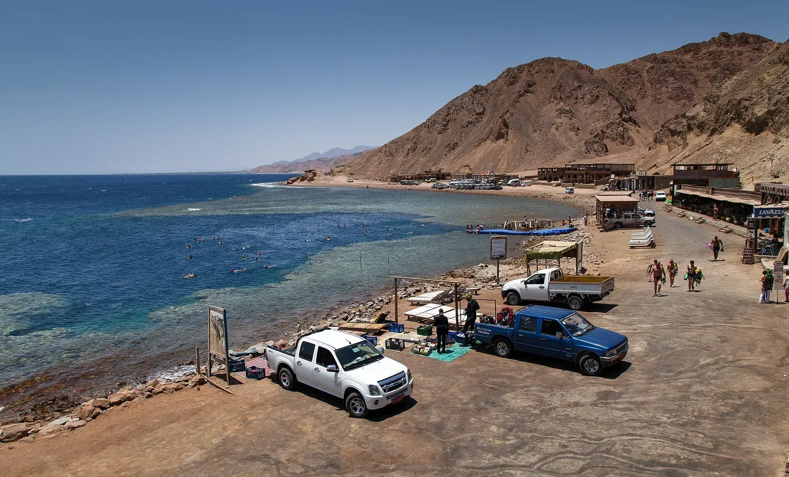 Coastal view of the Blue Hole dive site near Dahab with dive trucks along the shore