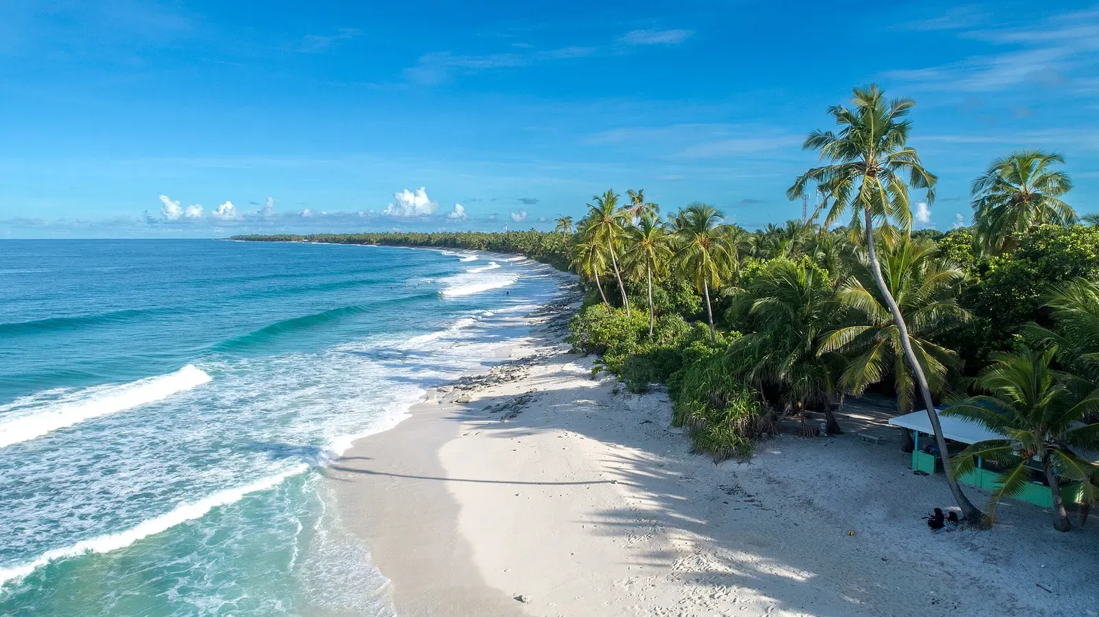 Aerial view of Fuvahmulah's palm-lined coastline and turquoise shallows