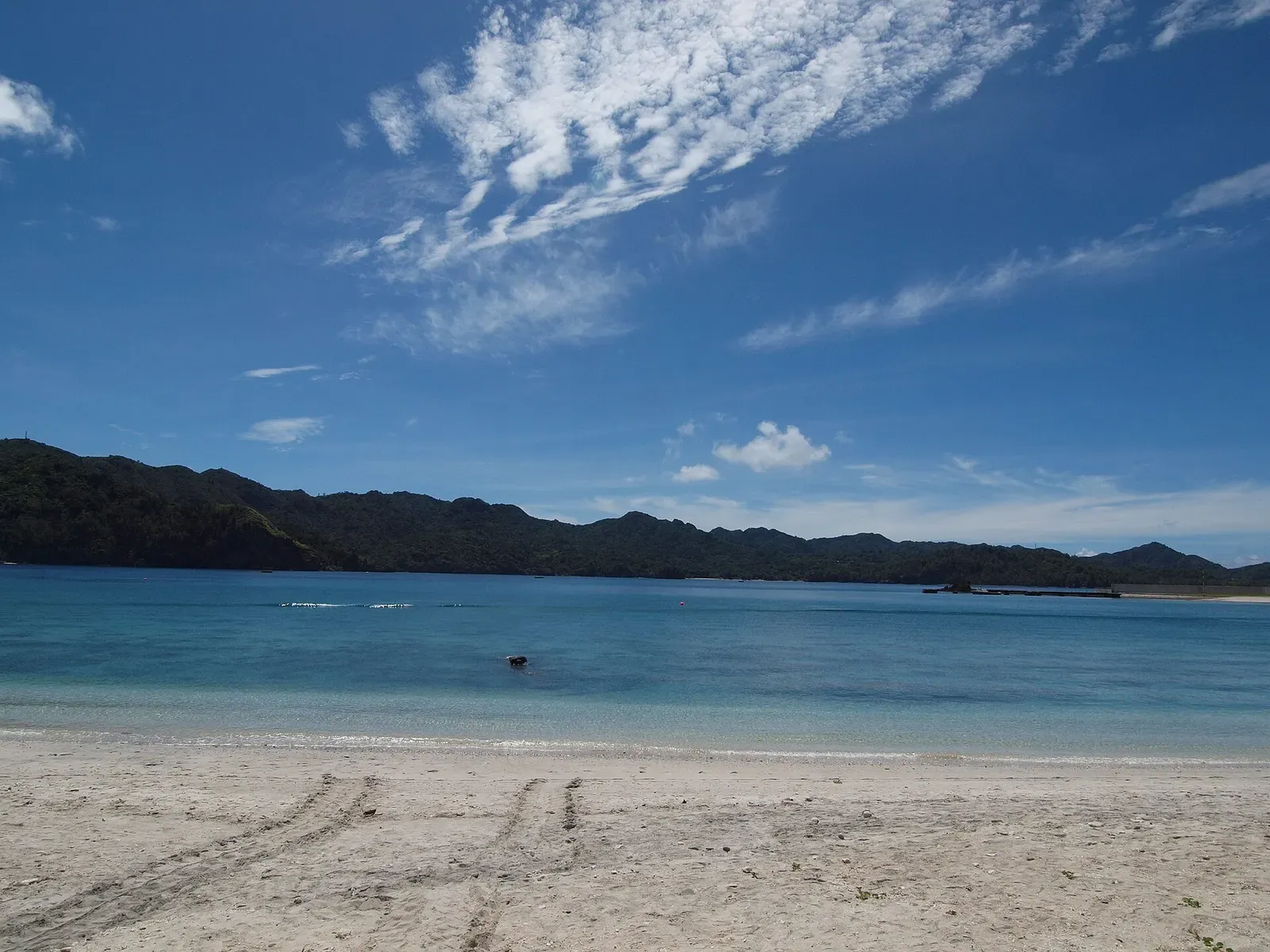 Turquoise lagoon of Omura Beach rimmed by forested hills on Chichijima, Ogasawara Islands