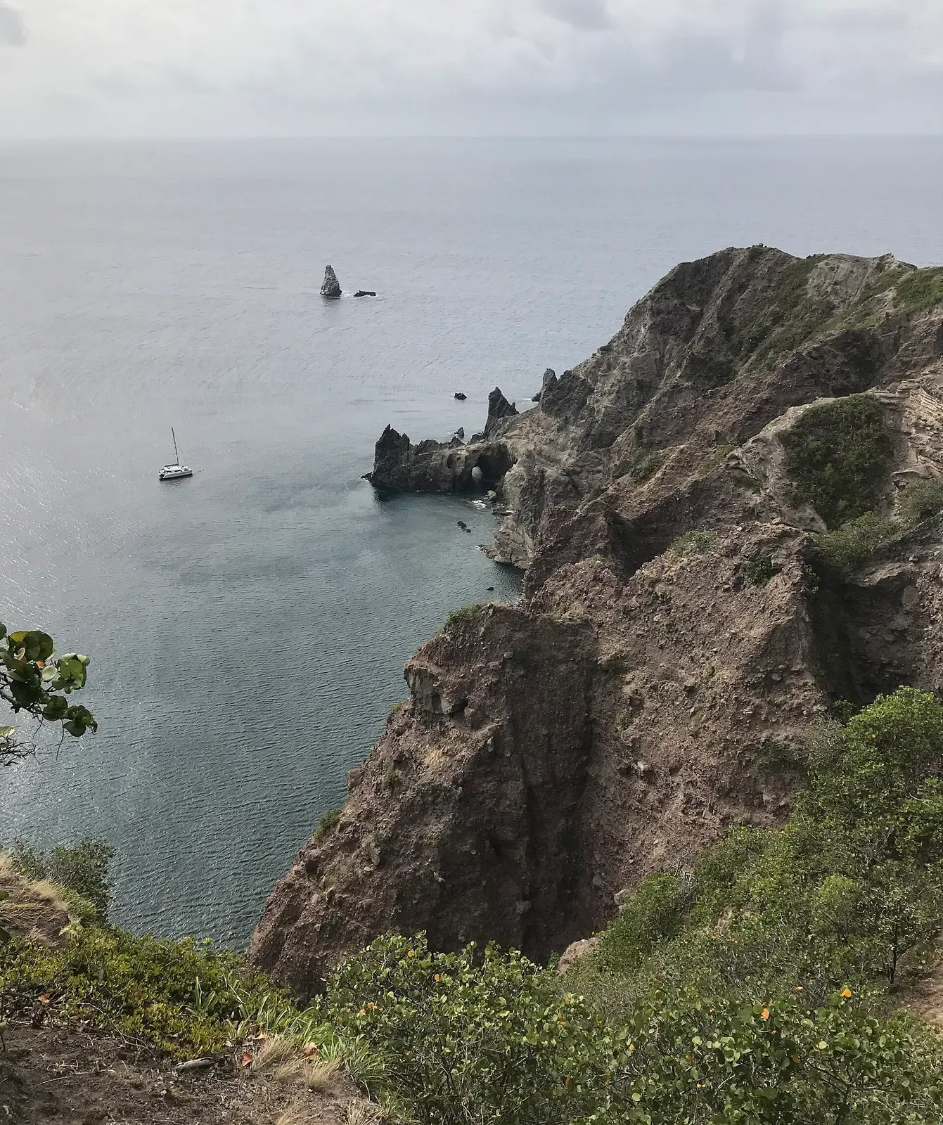 Wells Bay on Saba's coast, with the rock pinnacle of Torrens Point and a dive boat anchored offshore