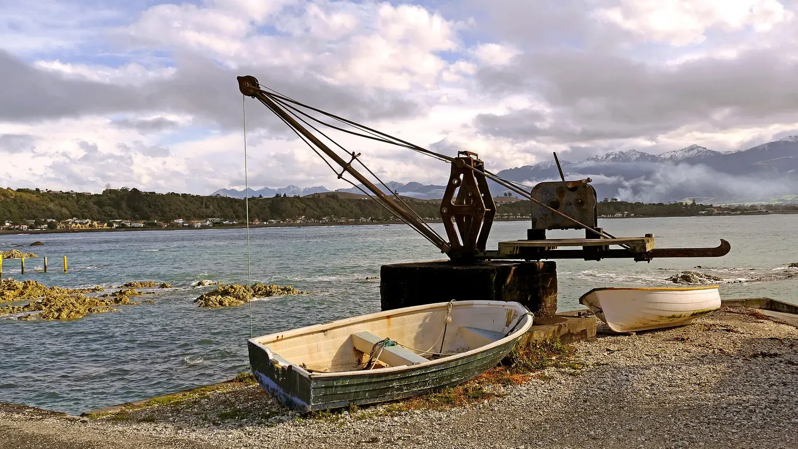 An old rowboat and derrick crane on the shingle beach at Kaikōura township