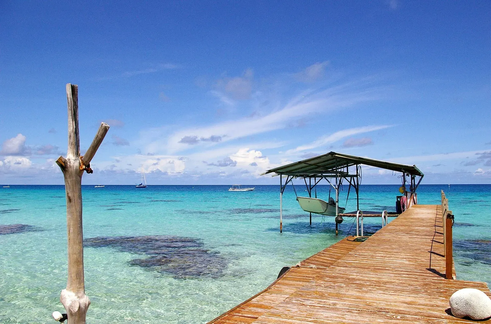 A wooden pontoon extends into Fakarava's turquoise lagoon near the village of Rotoava