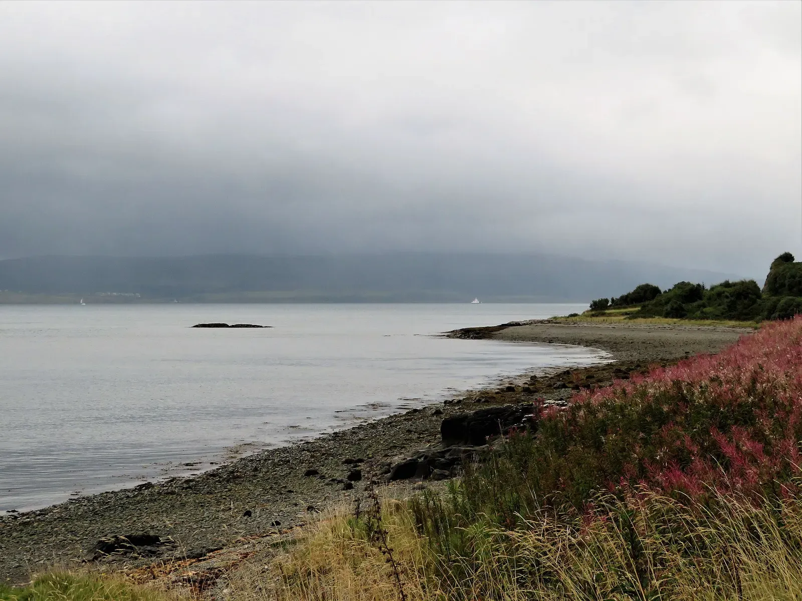 Misty view across a quiet bay on the Sound of Mull with a small rocky skerry