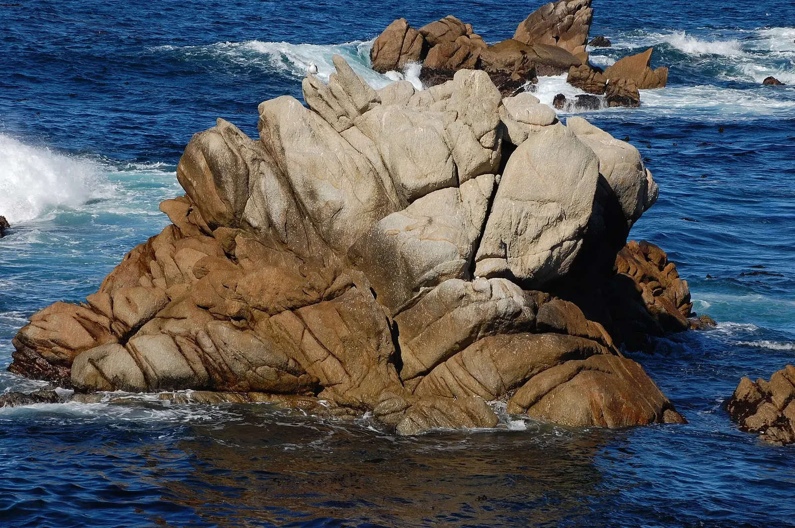 Weathered granite rock formations meet breaking surf at Point Lobos State Natural Reserve.